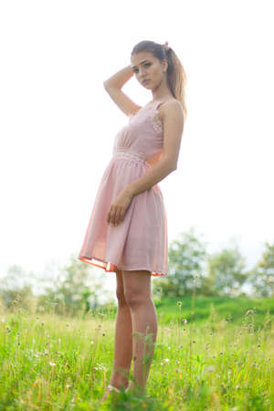 sexual girl has dissolved long hair sunny in the afternoon opposite blossoming white acaciaの写真素材