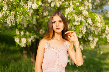 close-up portrait of a beautiful young girl in around white acacia in the springの写真素材