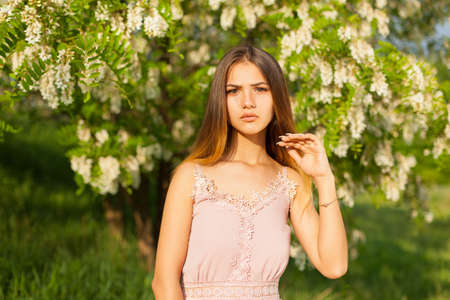 close-up portrait of a beautiful young girl in around white acacia in the springの写真素材