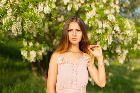 close-up portrait of a beautiful young girl in around white acacia in the springの写真素材