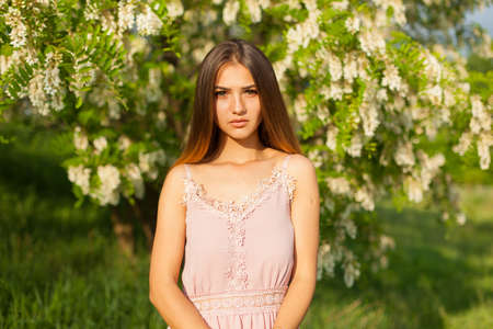 close-up portrait of a beautiful young girl in around white acacia in the springの写真素材