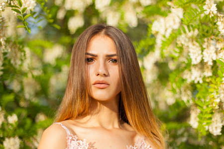 close-up portrait of a beautiful young girl in around white acacia in the springの写真素材