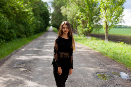 Beautiful slender Ukrainian woman walking along the asphalt roadの写真素材