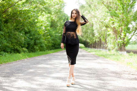 Beautiful slender Ukrainian woman walking along the asphalt roadの写真素材