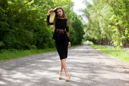 Beautiful slender Ukrainian woman walking along the asphalt roadの写真素材