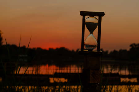 hourglass count down time against a red sunset background