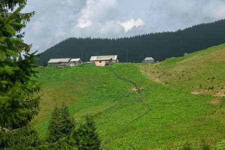 Wooden hut in Carpathians on the gorge under a cloudy skyの写真素材