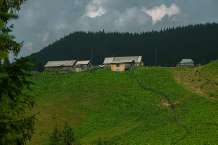 Wooden hut in Carpathians on the gorge under a cloudy skyの写真素材