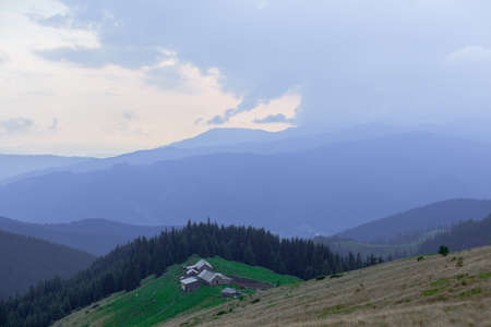 Wooden hut in Carpathians on the gorge under a cloudy skyの写真素材