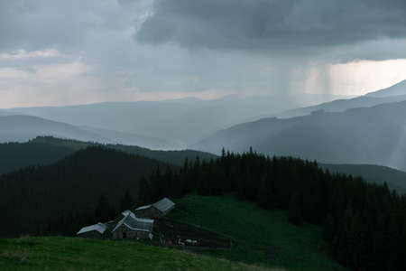 Wooden hut in Carpathians on the gorge under a cloudy skyの写真素材