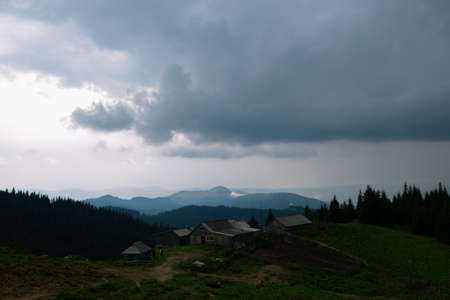 Wooden hut in Carpathians on the gorge under a cloudy skyの写真素材