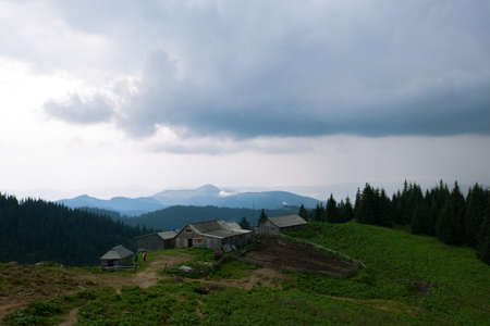 Wooden hut in Carpathians on the gorge under a cloudy skyの写真素材