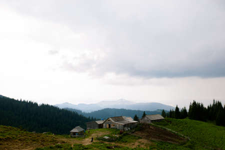 Wooden hut in Carpathians on the gorge under a cloudy skyの写真素材