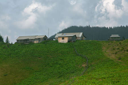 Wooden hut in Carpathians on the gorge under a cloudy skyの写真素材