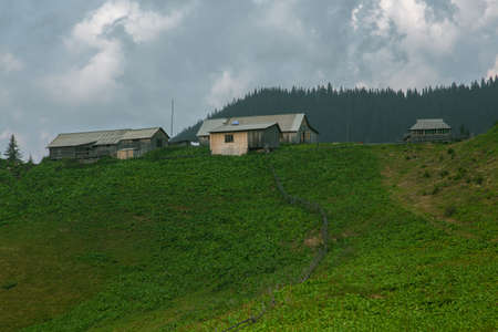 Wooden hut in Carpathians on the gorge under a cloudy skyの写真素材