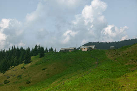 Wooden hut in Carpathians on the gorge under a cloudy skyの写真素材