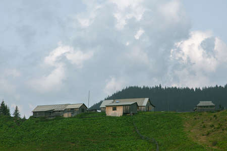 Wooden hut in Carpathians on the gorge under a cloudy skyの写真素材