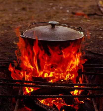 food in the cauldron is prepared on the wood open fire in the summer in nature in the marching versionの写真素材