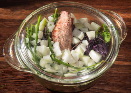grilled meat folded in a glass pan for cooking with onions and herbsの写真素材