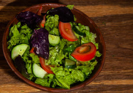 vegetarian diet salad in a plate on an oak tableの写真素材