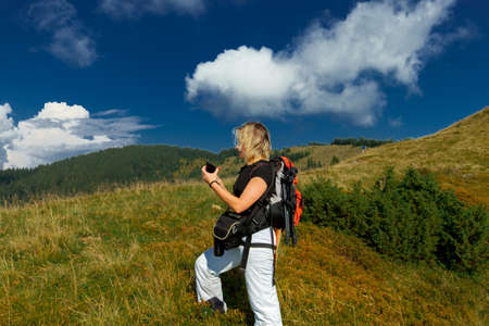 girl makes a selfie on a smartphone in the carpathians on the top of a mountainの写真素材