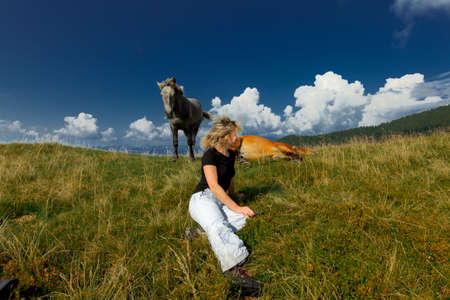 girl and horses on top of the mountainの写真素材