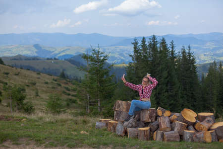 girl in stylish clothes high in the carpathians takes a selfie for social networksの写真素材