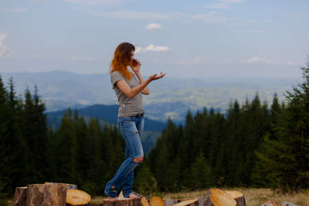 girl in a t-shirt and jeans posing in the summer high in the carpathian mountainsの写真素材