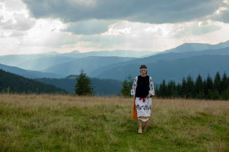 girl in embroidery in the carpathians on a cloudy sunny summer dayの写真素材