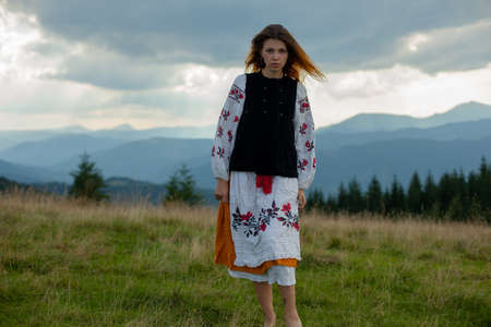 girl in embroidery in the carpathians on a cloudy sunny summer dayの写真素材
