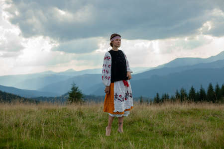 girl in embroidery in the carpathians on a cloudy sunny summer dayの写真素材