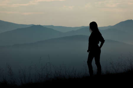 girl tourist high in the mountains sunset sun fog tops of the carpathiansの写真素材