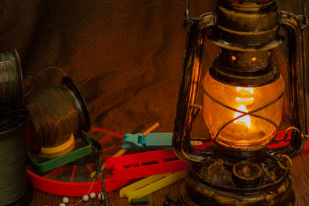 fishing line, hooks, sinkers, tools illuminated by an antique kerosene lampの写真素材