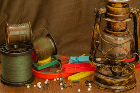 fishing line, hooks, sinkers, tools illuminated by an antique kerosene lampの写真素材