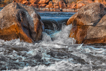 Stormy river rolls over stonesの写真素材