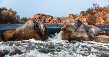 Stormy river rolls over stonesの写真素材