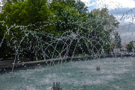 splashes of water close-up from the fountain against the background of the city parkの写真素材