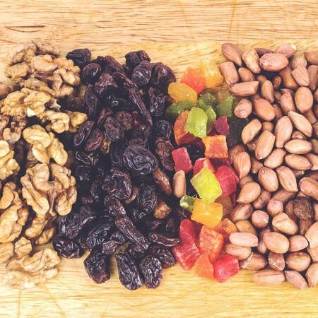 Mix of nuts and dry fruits on wooden background, close-up, top view  square imageの写真素材