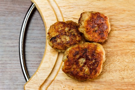 Juicy fried meat cutlets on wooden cutting board, top viewの写真素材
