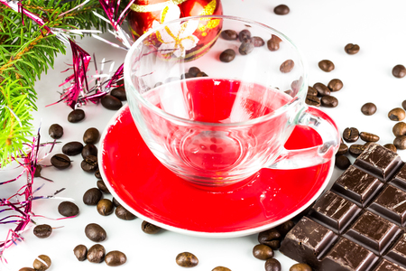 Xmas still life, empty glass cup, coffee beans, chocolate, christmas tree and ballsの写真素材