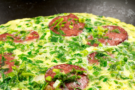Omelette with sausage and herbs in frying pan, selective focus, close-up.の写真素材
