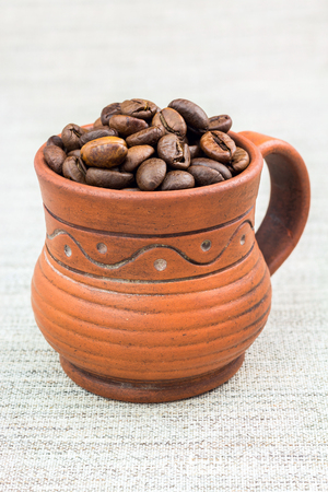 Pottery espresso cup full of coffee beans on the clothの写真素材