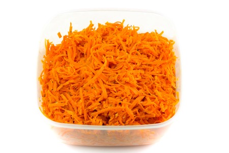 Spicy Salad of grated carrots in plastic container isolated on white backgroundの写真素材
