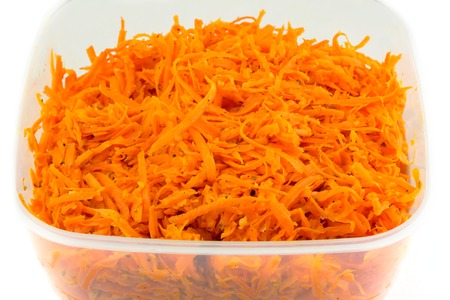 Spicy Salad of grated carrots in plastic container isolated on white backgroundの写真素材