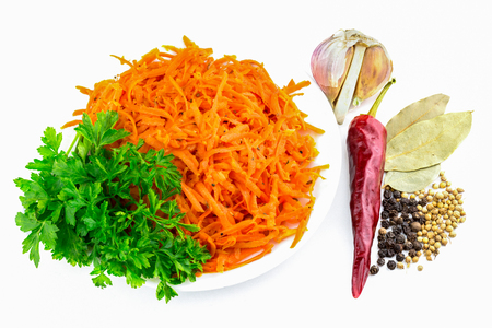 Korean carrots in plate with parsley and pepper, garlic bay leaf, isolated on white, still lifeの写真素材