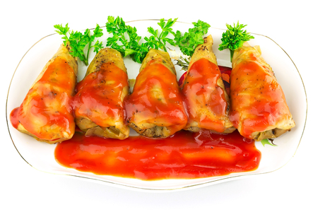 Cabbage roll with tomato sauce and parsley in plate, isolated on white background, in ukrainian holubtsiの写真素材