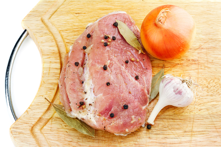 Raw meat before cooking with spices, onion and garlic on wood cutting board.の写真素材