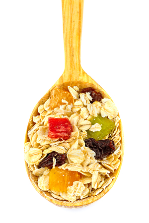 Cereal muesli or oat flakes with dried fruit on wooden spoon isolated on white backgroundの写真素材