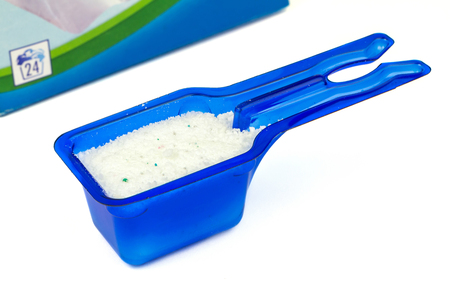 Laundry detergent or washing powder in blue measuring cup studio isolatedの写真素材