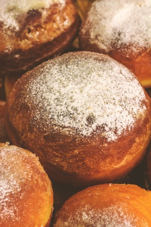 Homemade fresh donuts sprinkled with powdered sugar, close-up view, soft shadow processing